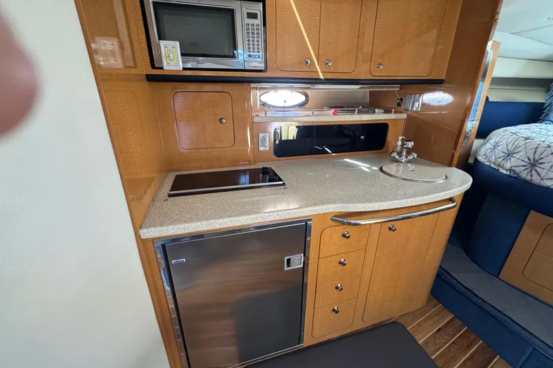 Slide: The Image of 2006 Chaparral Signature 350 yacht interior kitchen with microwave, sink, and fridge. - 37