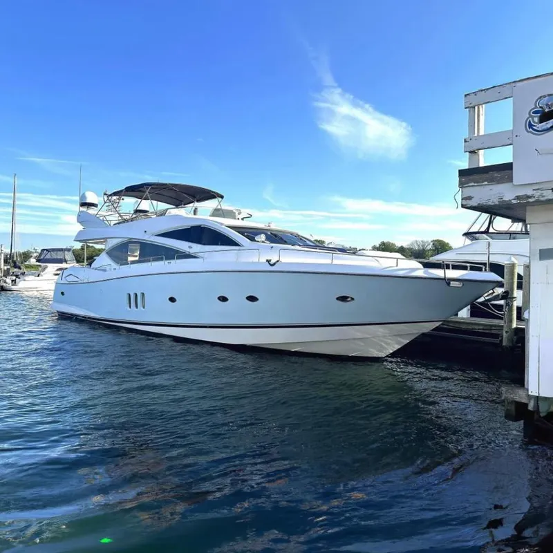 The Image of 2005 Sunseeker 75 Yacht docked in a marina under clear blue skies. - 0