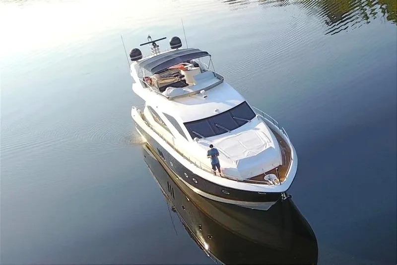 Slide: The Image of 2005 Sunseeker 75 Yacht cruising on a serene river surrounded by lush greenery. - 2