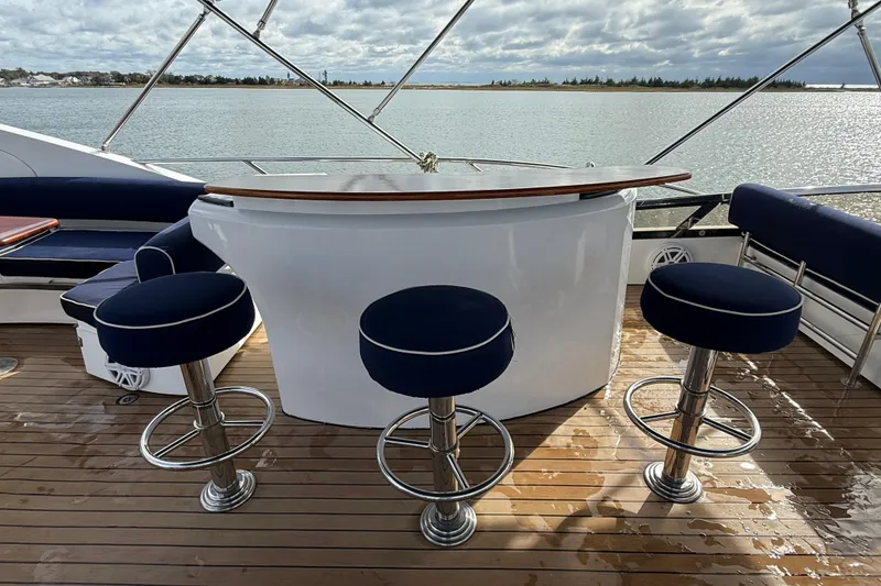 Slide: The Image of Luxury Sunseeker 75 Yacht 2005 deck with bar and stools, overlooking serene waters. - 38