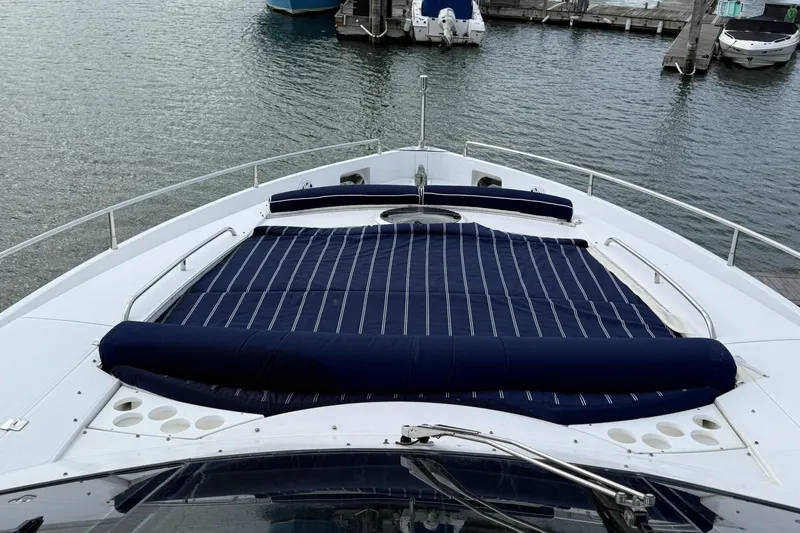 Slide: The Image of Sunseeker 75 Yacht 2005 bow with blue-striped sunbed, docked at marina. - 39