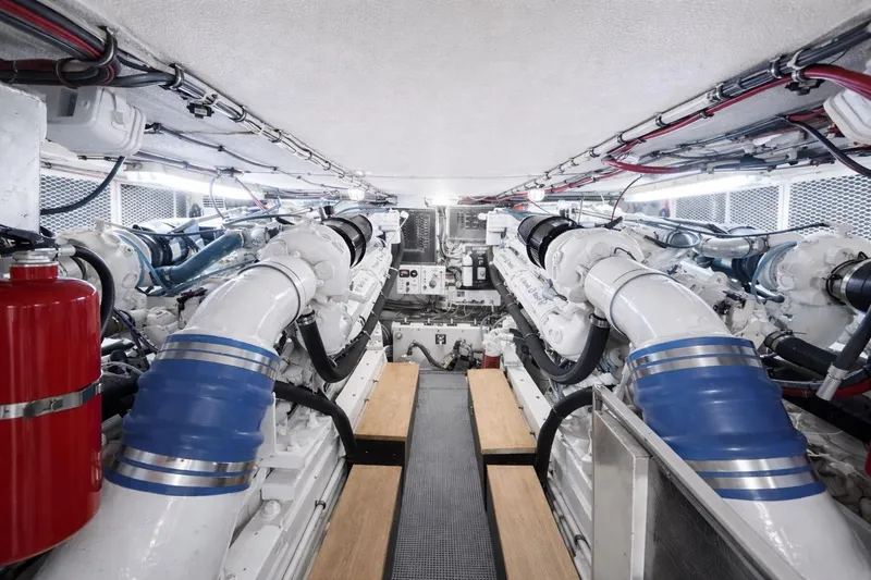 Slide: The Image of Engine room of a 1990 Hatteras 58 Convertible yacht, showcasing dual engines and piping. - 15