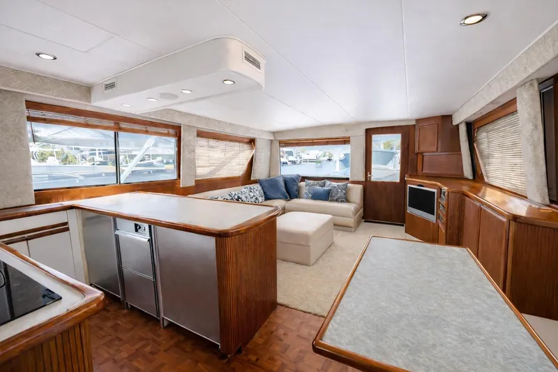 Slide: The Image of Luxurious interior of 1990 Hatteras 58 Convertible yacht with modern kitchen and cozy seating area. - 2