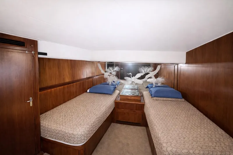 Slide: The Image of Interior of 1990 Hatteras 58 Convertible yacht with twin beds and wood paneling. - 6