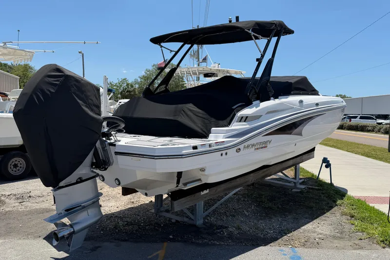 Slide: The Image of 2023 Monterey M-45 boat on trailer, covered and parked outdoors under clear sky. - 2