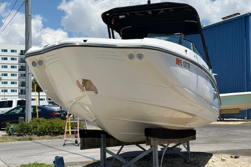 Slide: The Image of 2023 Monterey M-45 boat on display, elevated on stands, with a blue building backdrop. - 5