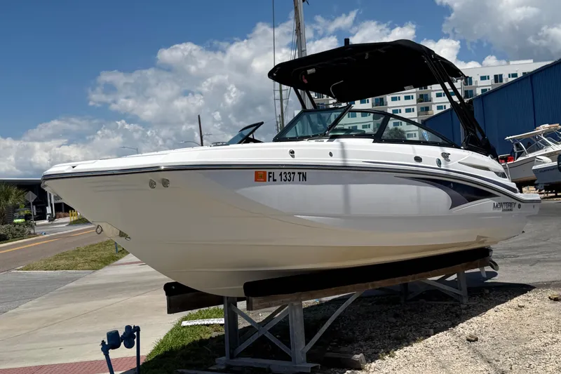 Slide: The Image of 2023 Monterey M-45 boat on display, white hull, black canopy, sunny day. - 6