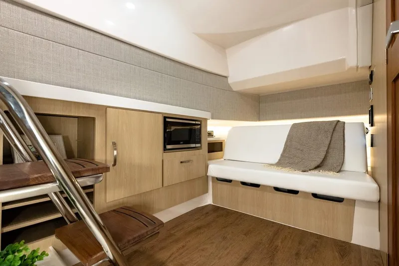 Slide: The Image of 2021 Regal 38 SAV interior with modern seating, wooden cabinetry, and a cozy blanket. - 25