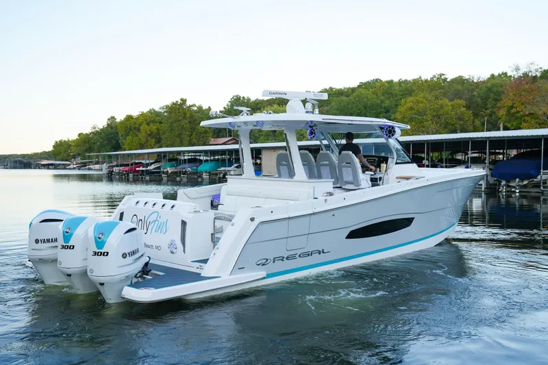 Slide: The Image of 2021 Regal 38 SAV boat with twin Yamaha 300 engines on a calm lake. - 3