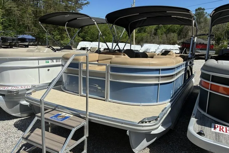 Slide: The Image of 2016 Bennington 22 SSRX pontoon boat with canopy, beige seating, and boarding steps. - 4