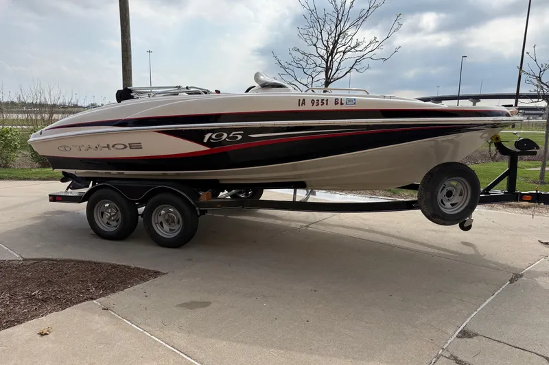Slide: The Image of 2013 Tahoe 195 I/O boat on trailer, parked outdoors on a cloudy day. - 5