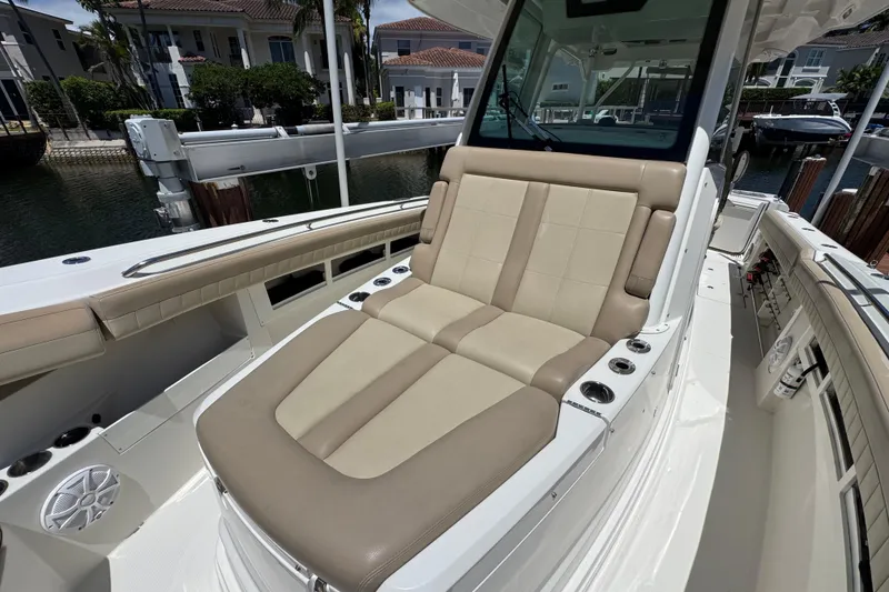 Slide: The Image of 2019 Sailfish 360 CC boat with beige seating, docked near waterfront homes. - 10