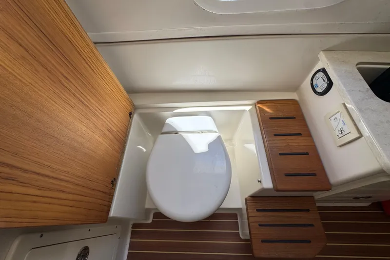Slide: The Image of Interior of 2019 Sailfish 360 CC featuring toilet and wooden accents. - 13