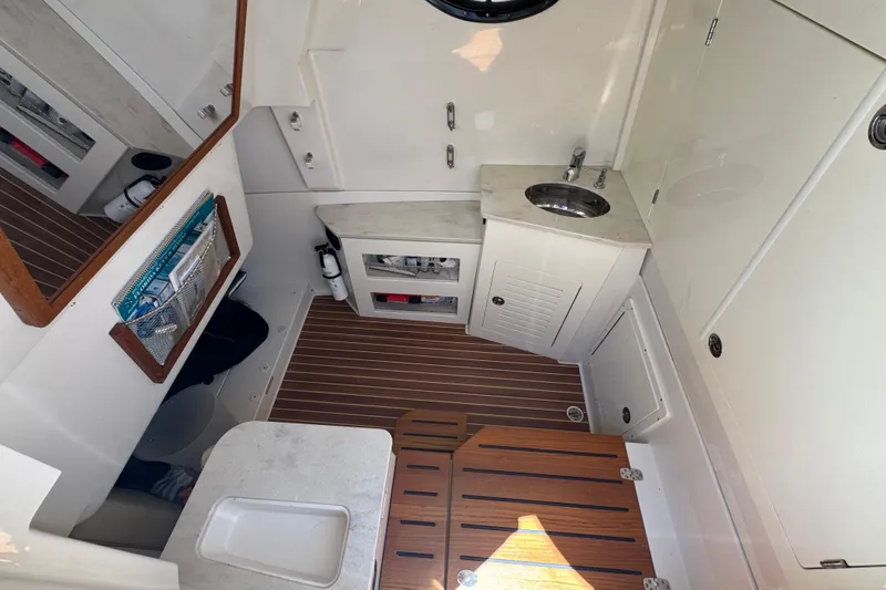 Slide: The Image of 2019 Sailfish 360 CC cabin interior with sink, storage, and wooden flooring. - 15