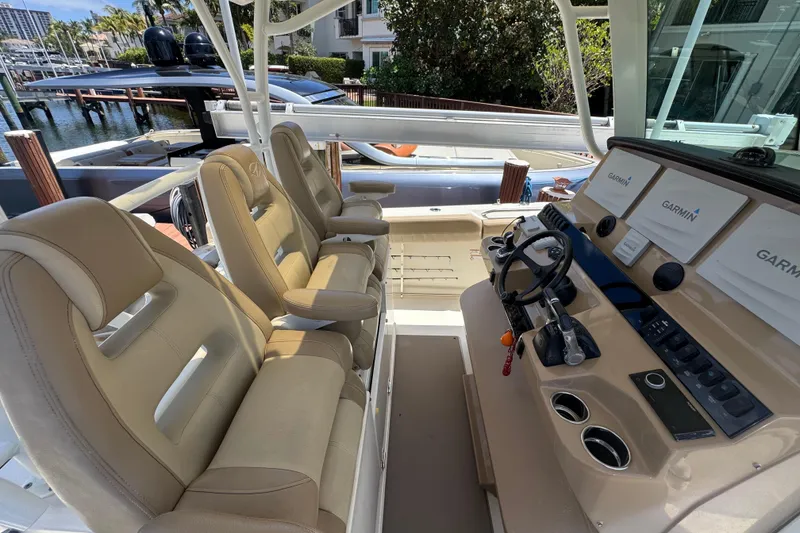 Slide: The Image of Interior view of 2019 Sailfish 360 CC boat with beige seating and Garmin navigation system. - 17