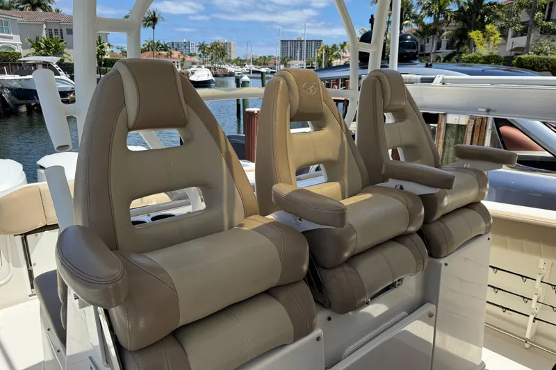 Slide: The Image of Luxury seating on a 2019 Sailfish 360 CC boat, docked in a scenic marina. - 18
