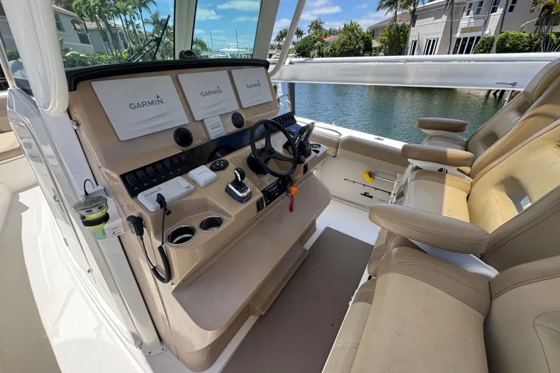 Slide: The Image of 2019 Sailfish 360 CC boat cockpit with Garmin navigation system and beige seating. - 19