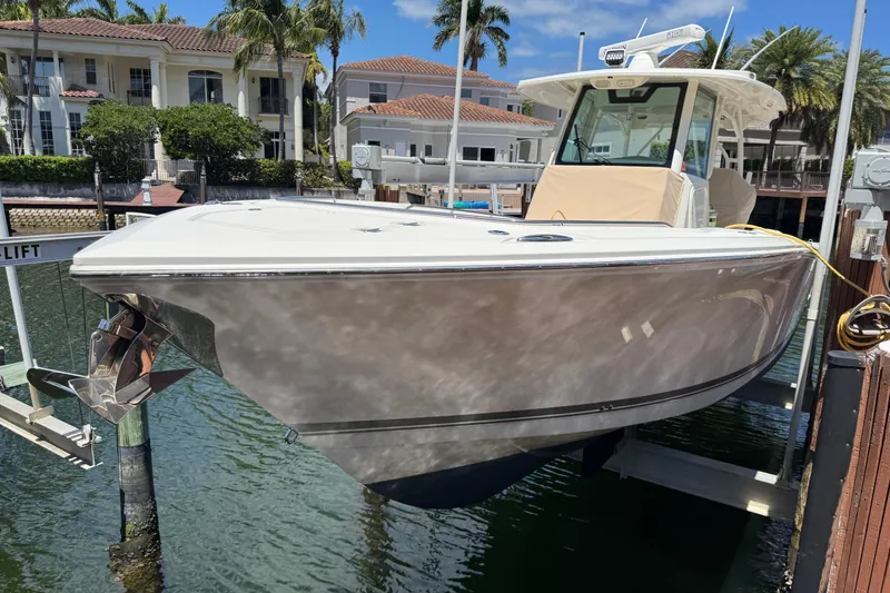 Slide: The Image of 2019 Sailfish 360 CC boat docked at marina with waterfront homes in background. - 2