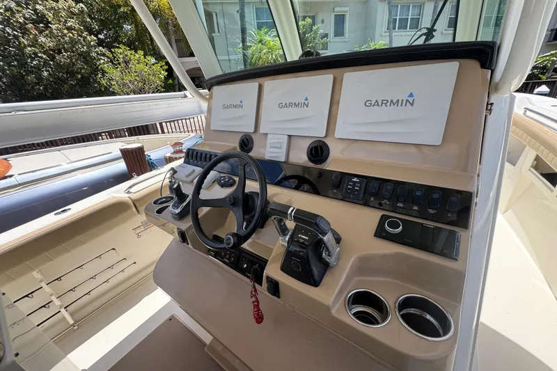 Slide: The Image of 2019 Sailfish 360 CC boat helm with Garmin navigation displays and steering wheel. - 23