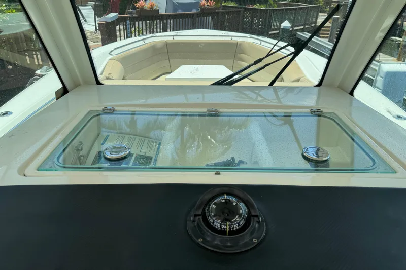 Slide: The Image of 2019 Sailfish 360 CC boat dashboard with compass and glass compartment. - 26