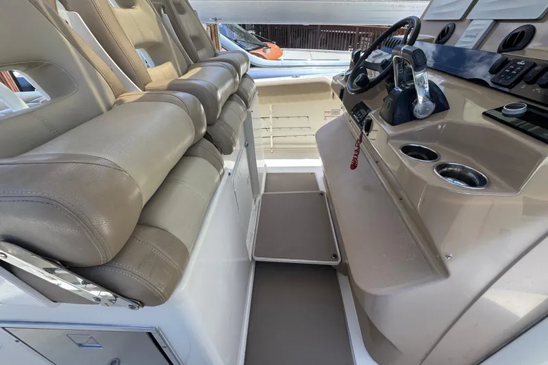 Slide: The Image of Interior of a 2019 Sailfish 360 CC boat featuring beige seating and a modern helm. - 27