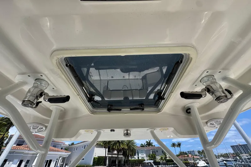 Slide: The Image of 2019 Sailfish 360 CC boat roof with hatch and rod holders, docked near waterfront homes. - 28