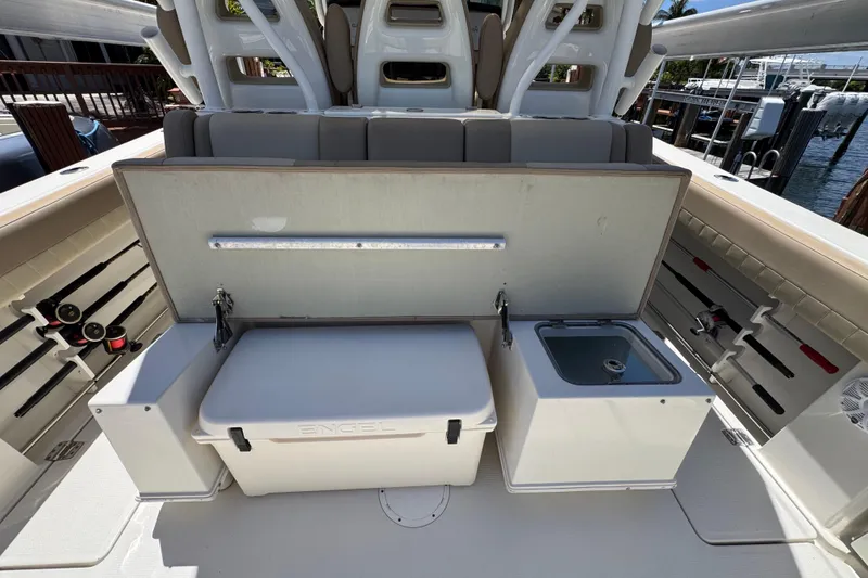 Slide: The Image of 2019 Sailfish 360 CC boat interior with storage, cooler, and sink setup. - 32
