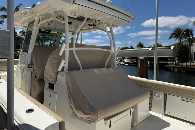 Slide: The Image of 2019 Sailfish 360 CC boat docked, featuring covered seating and clear skies. - 45