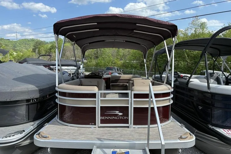 The Image of 2022 Bennington 22 SLX pontoon boat with canopy, parked outdoors under a clear sky. - 1