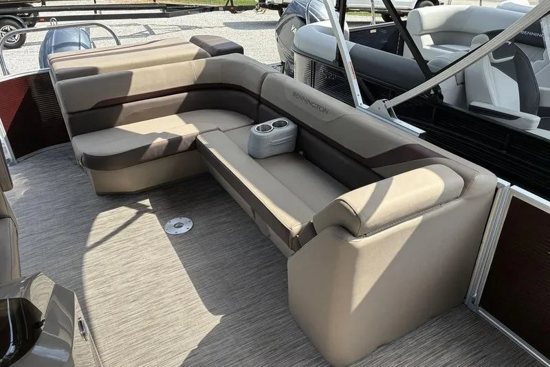 Slide: The Image of 2022 Bennington 22 SLX pontoon boat interior with beige seating and cup holders. - 3