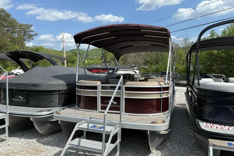 Slide: The Image of 2022 Bennington 22 SLX pontoon boat with canopy, parked outdoors under a clear sky. - 7
