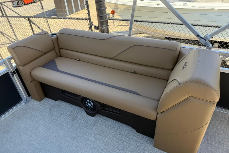 Slide: The Image of 2026 Avalon VENTURE QUAD LOUNGE with tan seating, cup holder, and speaker on a boat deck. - 19