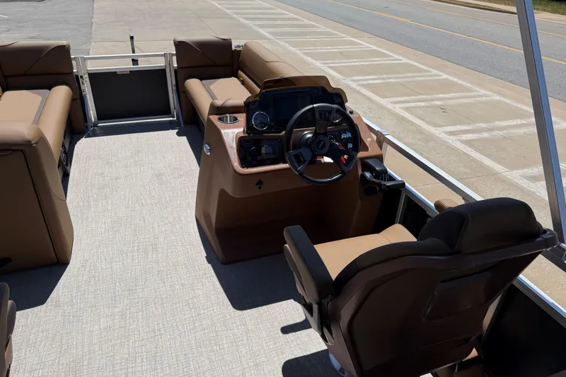 Slide: The Image of 2026 Avalon VENTURE QUAD LOUNGE boat interior with steering console and brown seating. - 22