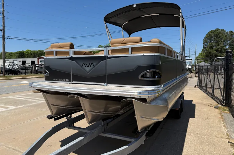 Slide: The Image of 2026 Avalon VENTURE QUAD LOUNGE pontoon boat on trailer, parked outdoors. - 3