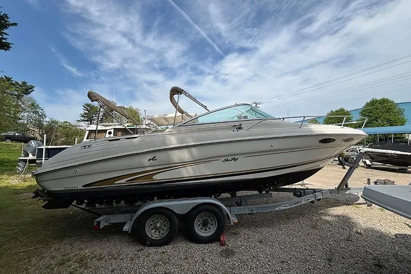 The Image of 2000 Sea Ray 260 Overnighter boat on trailer, parked outdoors under a clear sky. - 0