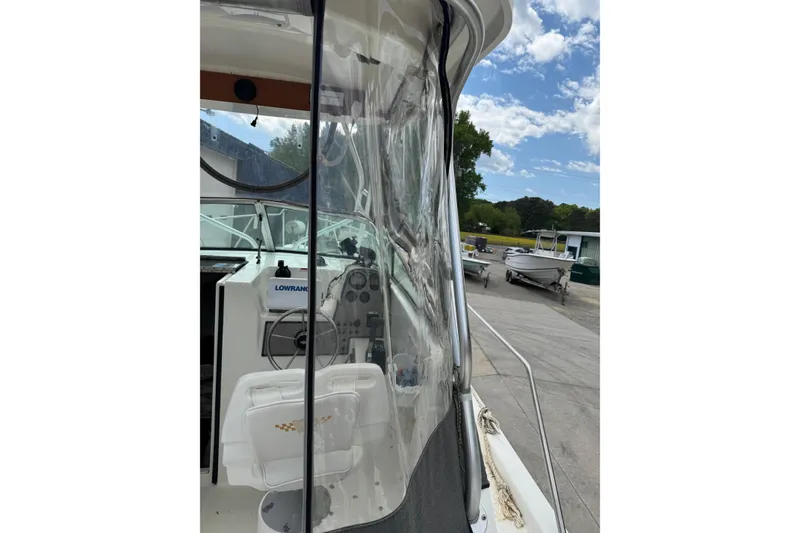 Slide: The Image of 2000 Wellcraft 22 Coastal Walkaround O/B boat with clear enclosure and visible steering console. - 17