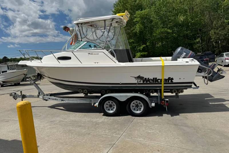 Slide: The Image of 2000 Wellcraft 22 Coastal Walkaround boat on trailer, parked outdoors. - 3