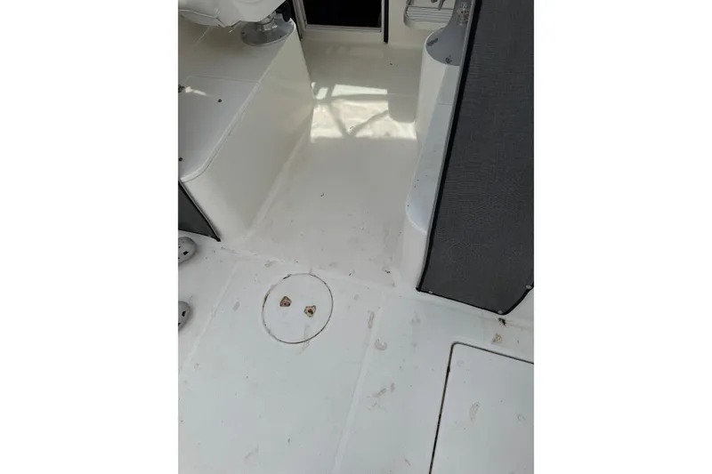 Slide: The Image of Interior deck of a 2000 Wellcraft 22 Coastal Walkaround boat, featuring clean white surfaces. - 8