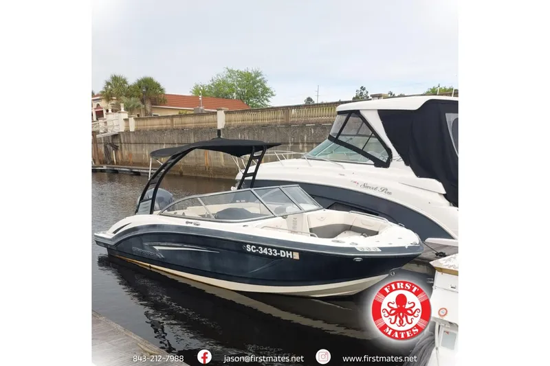 The Image of 2018 Chaparral 230 Suncoast boat docked, featuring sleek design and canopy. - 1