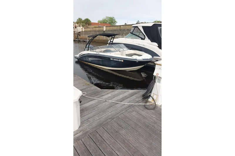 Slide: The Image of 2018 Chaparral 230 Suncoast boat docked at marina, featuring sleek design and black canopy. - 15