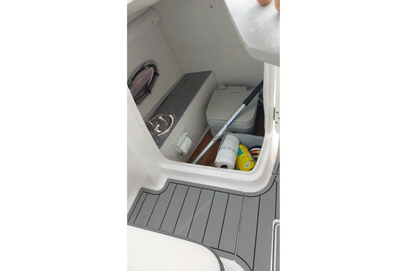 Slide: The Image of Interior storage compartment of 2018 Chaparral 230 Suncoast boat with cleaning supplies. - 18