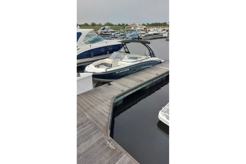 Slide: The Image of 2018 Chaparral 230 Suncoast boat docked at a marina, surrounded by other vessels. - 5