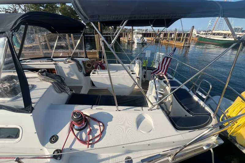 Slide: The Image of 2005 Jeanneau Sun Odyssey 40.3 sailboat docked, featuring spacious cockpit and American flag. - 12