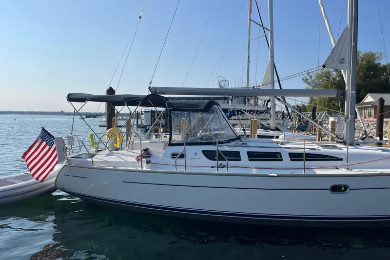 Slide: The Image of 2005 Jeanneau Sun Odyssey 40.3 sailboat docked with American flag displayed. - 2