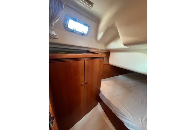 Slide: The Image of Cozy cabin interior of 2005 Jeanneau Sun Odyssey 40.3 with wooden cabinetry and bed. - 34