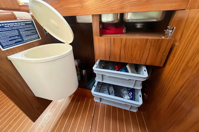 Slide: The Image of Interior storage of 2005 Jeanneau Sun Odyssey 40.3 yacht with open cabinet and trash bin. - 41