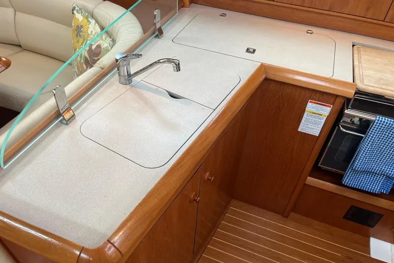 Slide: The Image of Jeanneau Sun Odyssey 40.3 2005 yacht kitchen with sink, stove, and wooden cabinetry. - 42