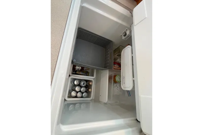 Slide: The Image of Open fridge on Jeanneau Sun Odyssey 40.3 yacht, stocked with beverages and food items. - 44
