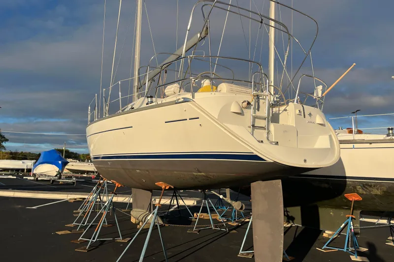 Slide: The Image of 2005 Jeanneau Sun Odyssey 40.3 sailboat on stands in a marina under a cloudy sky. - 55