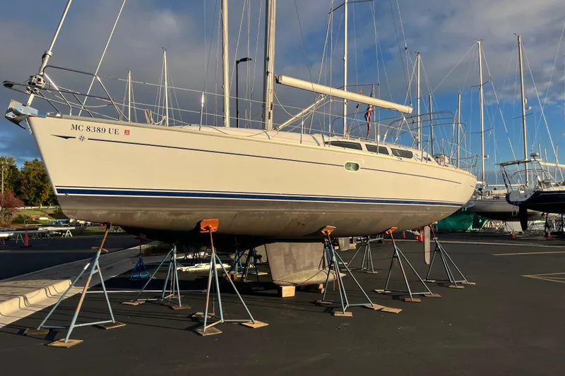 Slide: The Image of 2005 Jeanneau Sun Odyssey 40.3 sailboat on stands in a marina, clear sky background. - 56